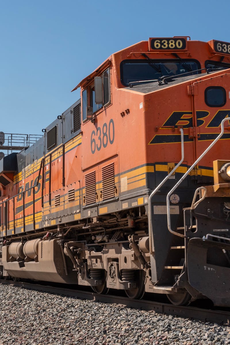 A powerful freight train traveling on tracks with scenic California mountains in the background.